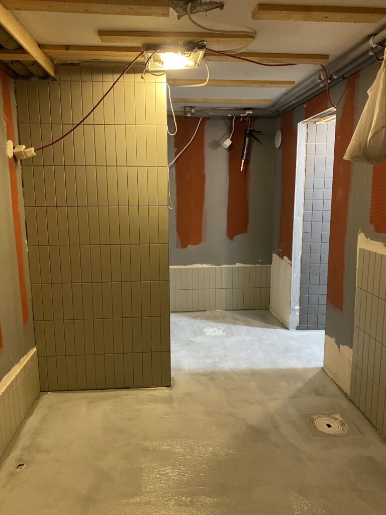 Veden roiskeille altteille pinnoille laatoitettiin laattapinnat ja rajattiin tilaa väliseinäkkeellä.