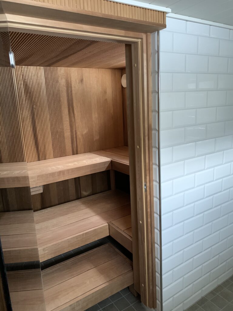 Uudelleen paneloitu sauna ja uudet lämpökäsitellystä puusta paikanpäällä tehdyt lauteet.